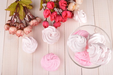 Zefir or marshmallow roses on a wooden stand as part of sweet dessert table or candy bar. Wedding party. Top view.