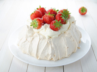 Pavlova cake with strawberry on rustic background