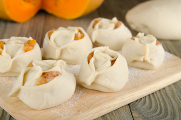 Manti. Asian national dish with meat and pumpkin on rustick wood background.