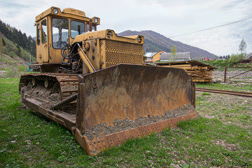 Fototapeta premium Old yellow bulldozer in the highlands. Industry