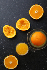 Fototapeta na wymiar Fresh oranges juice in glass on slate background