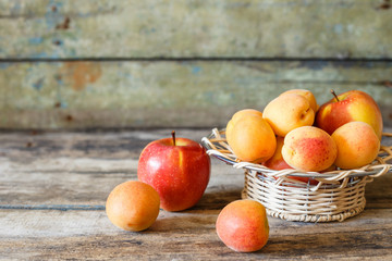 Ripe apricots in white bowl on wooden background