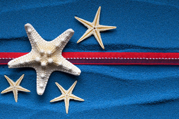 Starfish and red ribbon on blue background