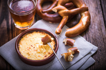 Hot cheese fondue with pretzel