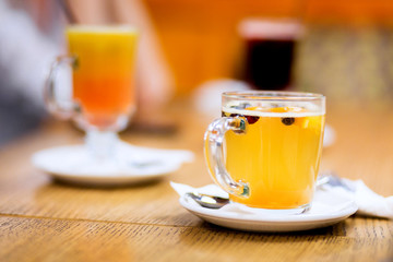 Tea with sea buckthorn and honey on cafe background