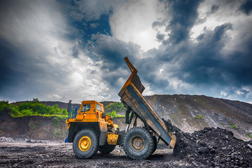 NOVOKUZNETSK, RUSSIA - JULY 26, 2016: Big yellow mining trucks and excavators at worksite
