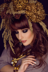 Beautiful young woman with dry flowers on head