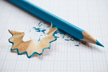 crayon de couleur bleu et taillure sur cahier d'écolier