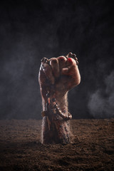 Human hand in blood and dirt with rosary