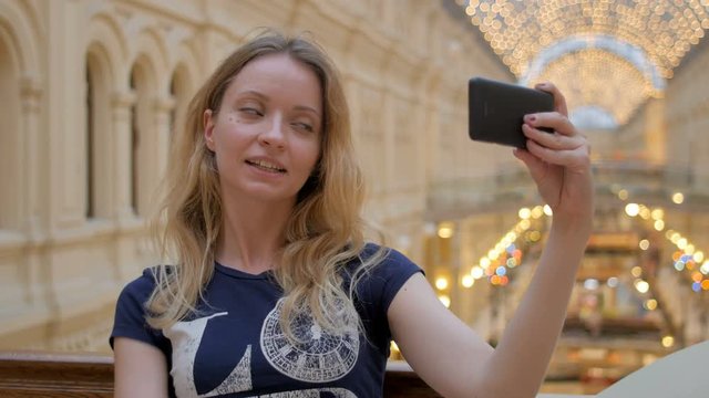 young slim blonde taking selfie in shopping mall