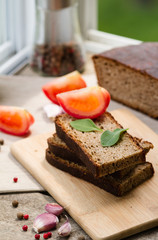 Rye bread. Bread on a wooden table, tomatoes and garlic