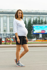 A pregnant woman stands on the square