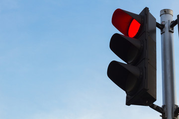 red color on the traffic light with a clear beautiful blue sky as background