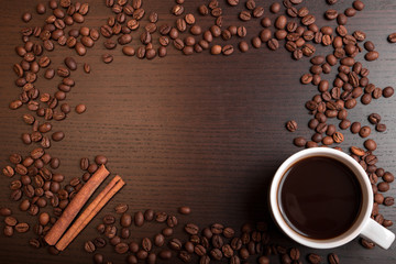 Cup of coffee, coffee beans and cinnamon with space for text