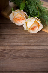 Fototapeta premium pastel roses on vintage wood background, free copy space