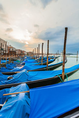 Fototapeta na wymiar Pier gondolas near Piazza San Marco in Venice at sunrise. A number of boats on the background of the waterfront in Venice. Italy