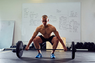 Fototapeta na wymiar Young athlete doing snatch exercise at the gym