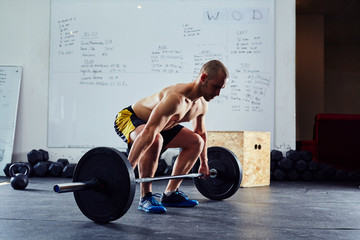 Young man doing power snatch exercise at gym