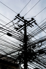 Silhouette messy black power and telephone wire on a concrete po