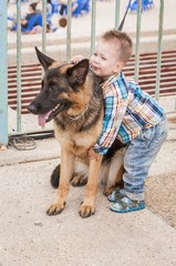 TEL AVIV, ISRAEL. May 6, 2014. Caucasian little boy with a german shepherd dog.