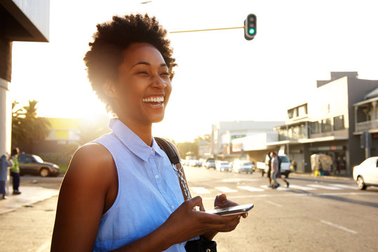 Attractive Woman With Mobile Phone Looking Away And Laughing