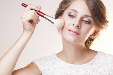 pretty make up artist girl with brush next to face