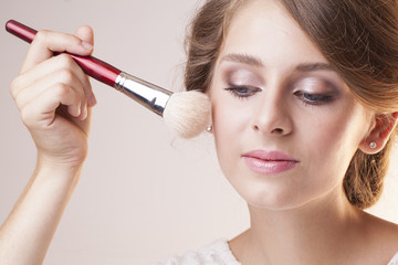 pretty make up artist girl with brush next to face