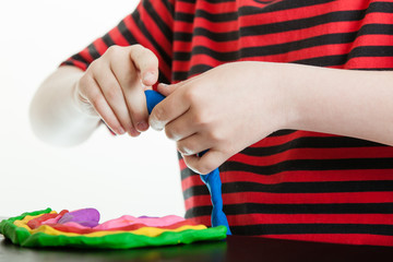 Hands of a young boy playing with plastic putty