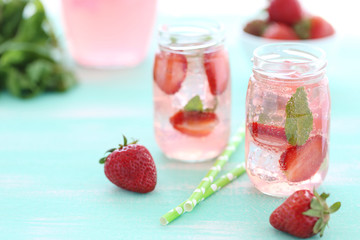 Fresh strawberry drink in bottle on wooden table