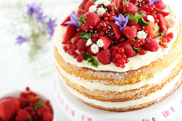 Delicious biscuit cake with berries on cake stand