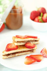 French toasts with chocolate and strawberry on wooden table