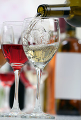 White wine pouring into glasses, closeup