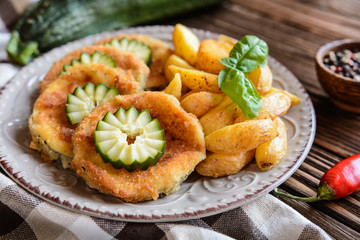 Breaded fried zucchini with American potatoes and cucumber