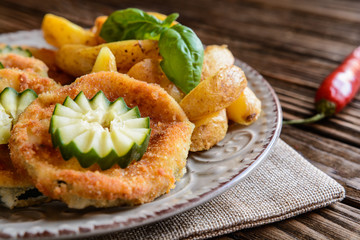 Breaded fried zucchini with American potatoes and cucumber