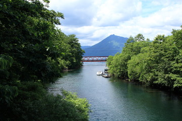 the lake shikotsu. A mountain and river with a red iron bridge