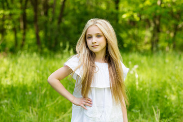 Portrait cute blonde girl outdoors in summer