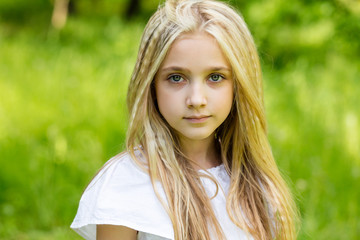 Naklejka premium Portrait cute blonde girl outdoors in summer