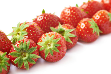 Line of red strawberries isolated