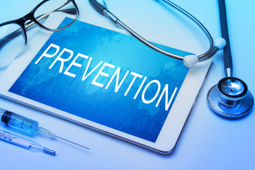 Prevention word on tablet screen with medical equipment on background