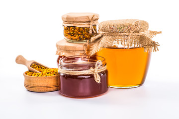 Still life with honey, honeycomb, pollen and propolis on a white