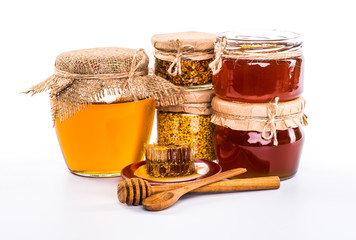 Still life with honey, honeycomb, pollen and propolis on a white