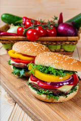 homemade hamburger with fresh vegetables on cutting board