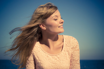 Lovely blonde girl relaxing outdoor by seaside