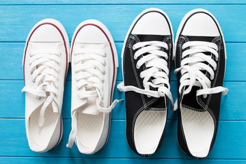 Two pairs of canvas shoes on a blue wooden