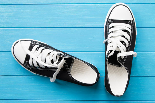 A pair of black canvas shoes on a blue wooden