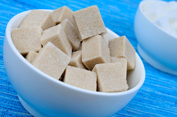 Bowl with sugar cubes on table