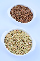 Buckwheat in ceramic bowls on background