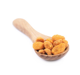 Spoon filled with the breaded peanuts