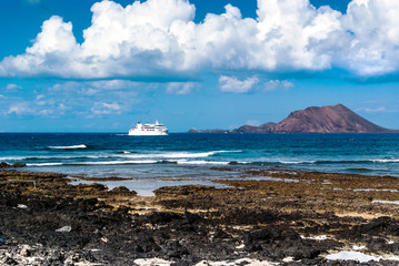 Beautiful seascape with island and the ferry in the background. Fuerteventura. Canary Islands. Spain