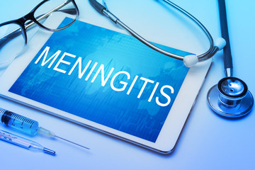 Meningitis word on tablet screen with medical equipment on background